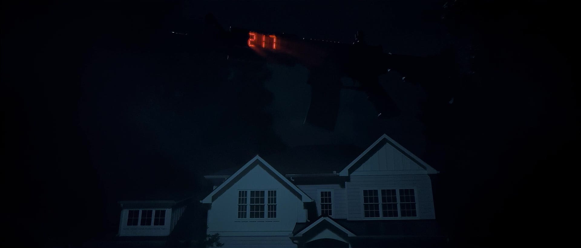 A shot of a large suburban house at night. Abnove the house floats a giant assault rifle. On the rifle's side is a digital clock readout: 2:17.