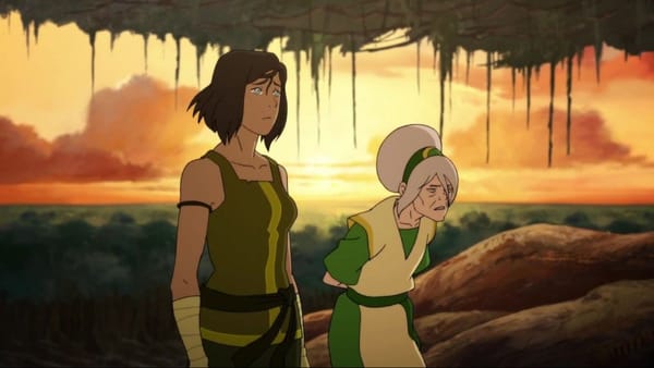 A still from The Legend of Korra. Korra, in a green tank top, walks beside an elderly Toph in front of a setting sun.